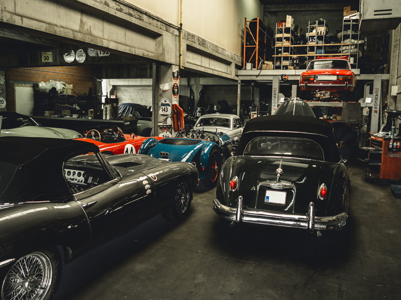 vintage car, retro styled, bumper, car, car show, automobile, motor vehicle, city, bus, human, outdoors, mode of transportation, wheel, land vehicle, built structure