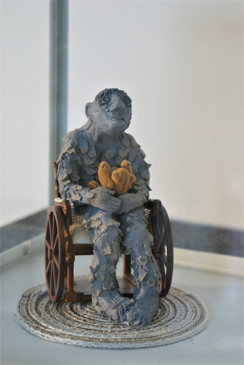 clay sculpture, table, mammal, indoors, artwork, sound, animal themes, figurine, art, day, melancholic, figure, plastic, focus on foreground, mood, creativity