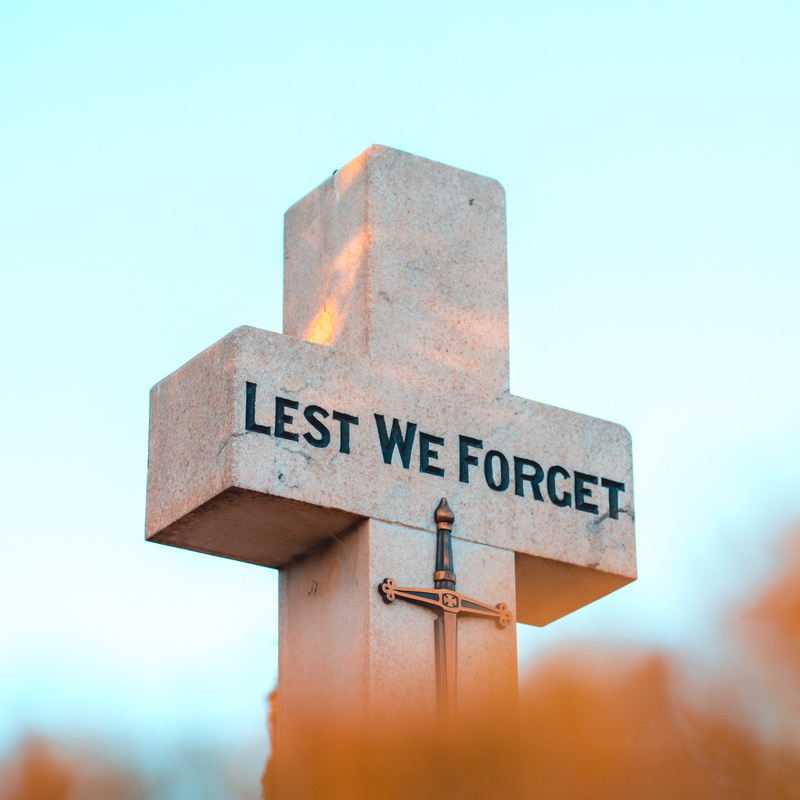 sky, blue, symbol, sign, text, remembrance day, lest we forget, close-up, arrow symbol, day, cross, blue background, western script, direction, information sign