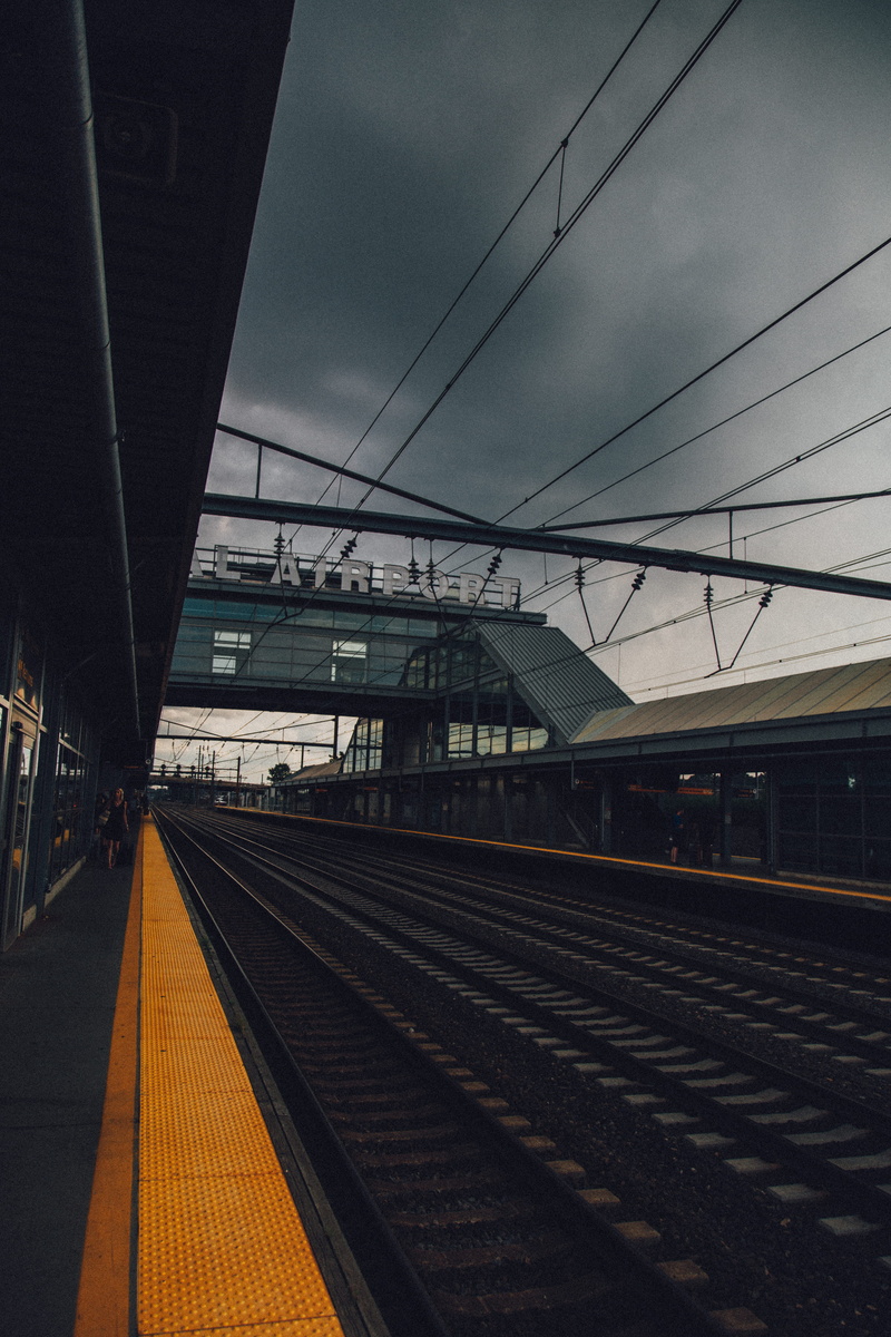 daytime, building exterior, rail transportation, track, built structure, terminal, no people, clouds, sky, person, airtrain, railroad station, outdoors