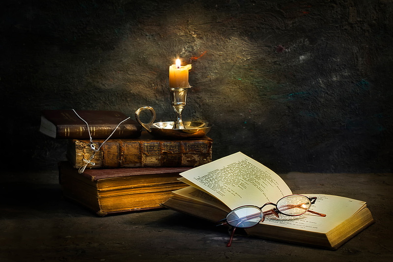 cross, antique, eyeglasses, lighting equipment, literature, glass, flame, fire, gray, candlestick holder, table, container, wood - material, burning, books