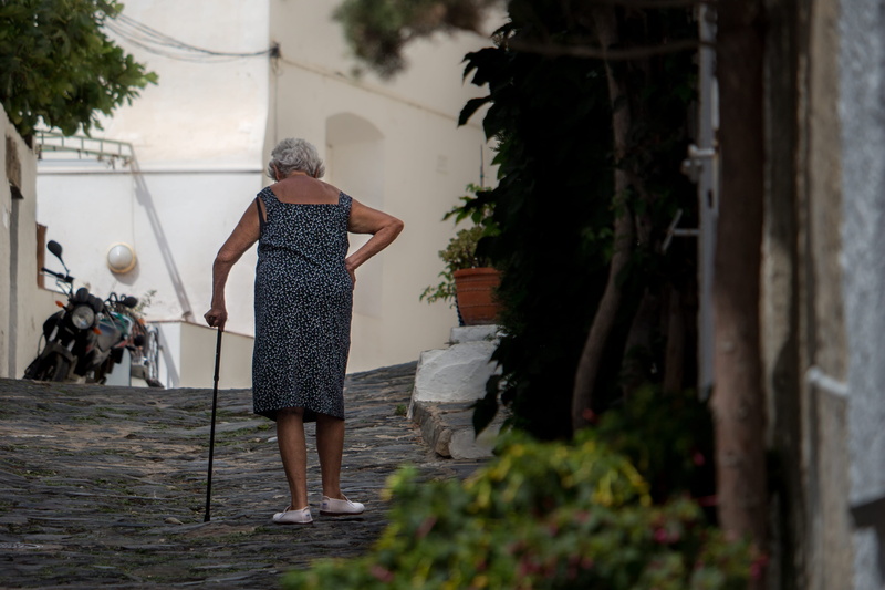 rear view, costabrava, outdoors, tall, street, woman, architecture, walking, real people, leisure activity, walking stick, ground, one person, standing
