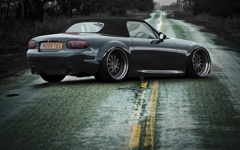convertible, transportation, sign, sports car, travel, rain, outdoors, reflection, day, rainy season, land vehicle, coupe, gray, water, muscle cars, nature
