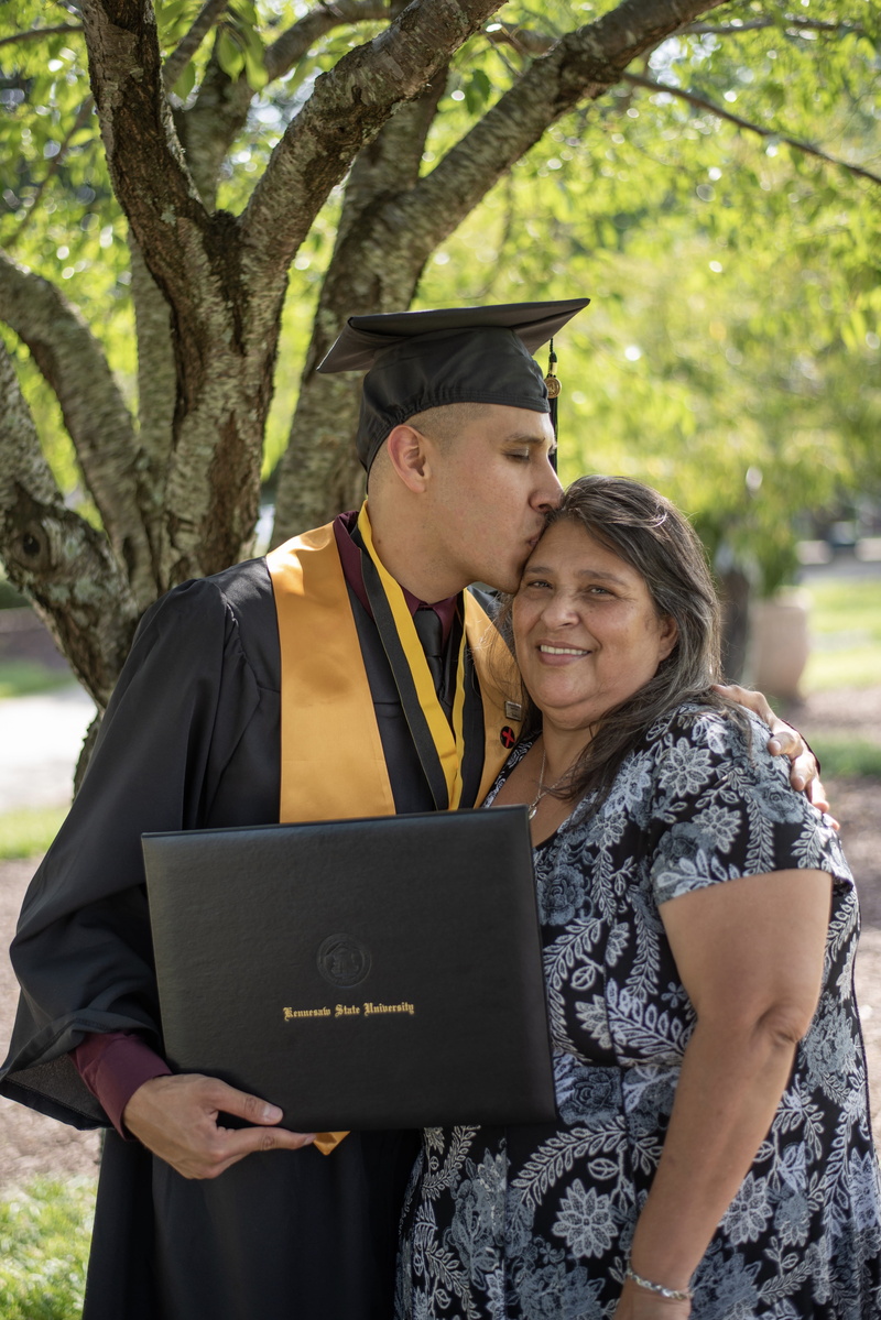 education, graduation, woman, graduation gown, black, outdoors, head, happiness, kissing, people, gown, togetherness, adult, front view, man, holding, women