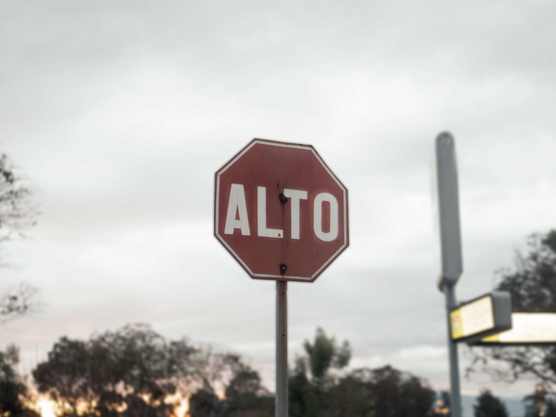word, town, cloud - sky, focus on foreground, day, information, nature, bus stop, city, goggles, plant, sign, sky, arrow, outdoors, communication, capital letter
