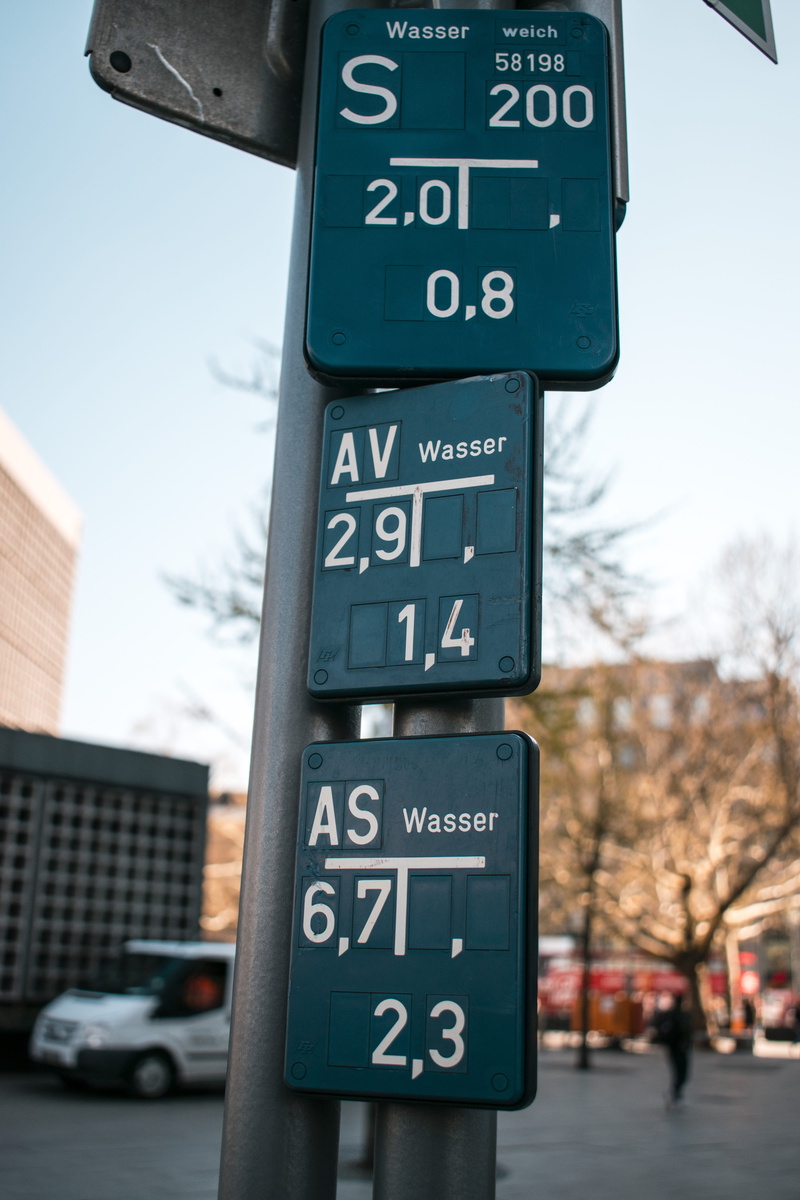city, tarmac, symbol, outdoors, asphalt, architecture, street, 5K, bus stop, stopsign, focus on foreground, emblem, road, person, number, western script