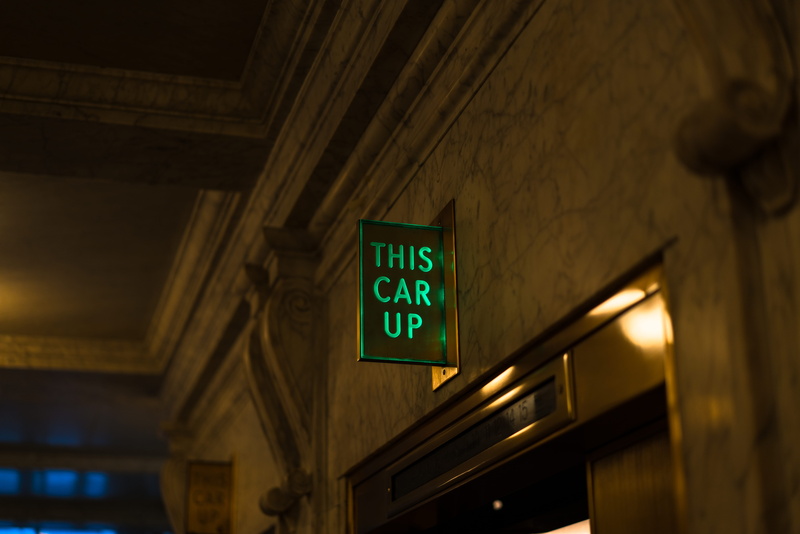 architecture, information, ceiling, lighting equipment, indoors, built structure, sign, this car up, exit sign, directional sign, Going Up, wall - building feature