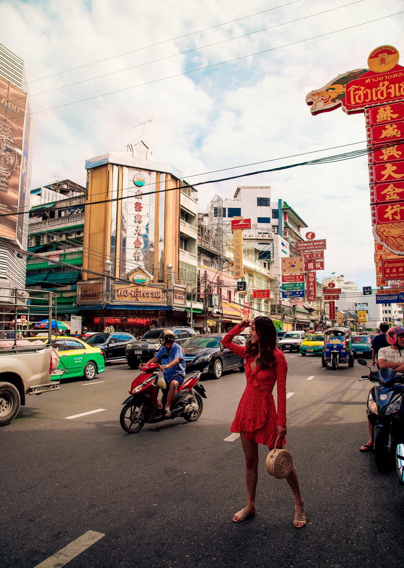 surrounded, motorbike, bag, incidental people, woman, red dress, chinatown, colol, outdoors, car, holding, person, pose, architecture, motor, sign, scooter
