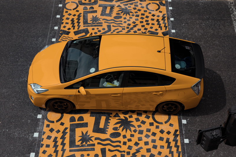 prius, outdoors, mural, sedan, taxi, land vehicle, communication, yellow taxi, united kingdom, luggage, yellow, day, sign, london, floor, high angle view