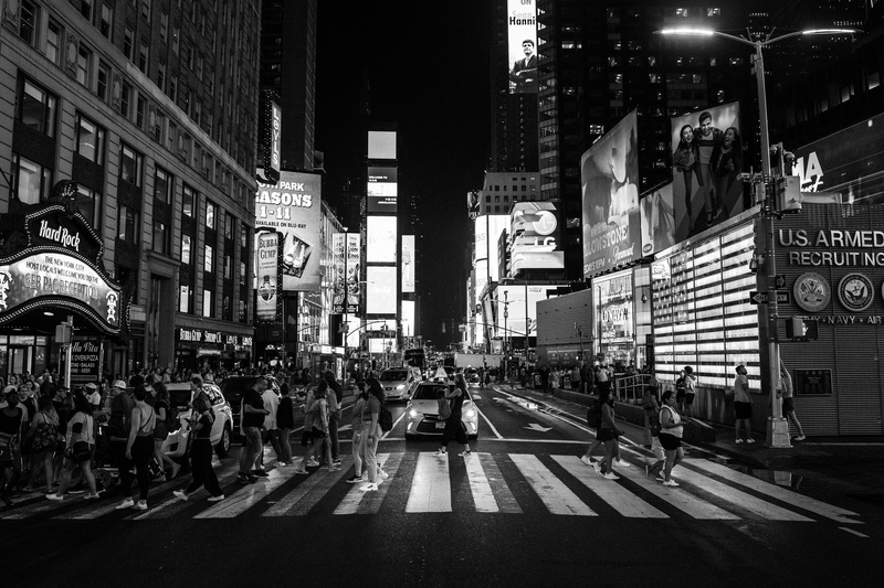 crowd, building exterior, city street, office building exterior, symbol, city, building, crossing, crosswalk, city life, transportation, night, road marking