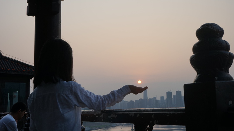 city, hairstyle, outdoors, human arm, 5K, dusk, building exterior, people, females, sky, human body part, waist up, women, arms raised, architecture, hongya cave