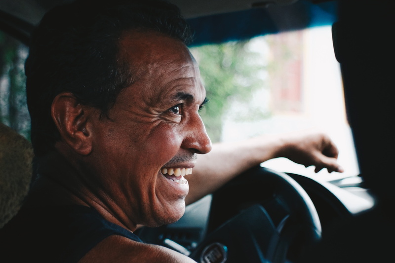 man in blue, vehicle interior, one person, mature men, headshot, portrait, men, expression, smile, adult, blue, looking, retro, emotion, profile view, focus on foreground