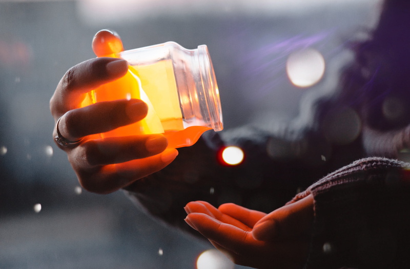 bottle, person, dark, night, blur, palm, human body part, indoors, human hand, lights, unrecognizable person, close-up, lens flare, yellow, 4K, honey