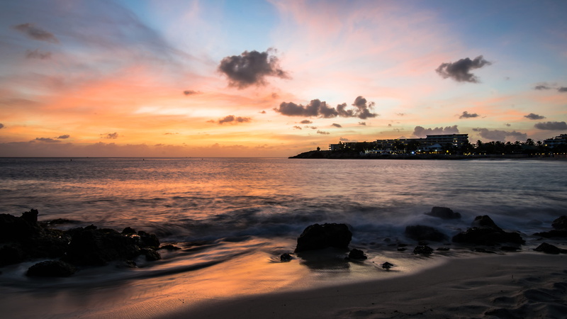 ocean, red sky, tranquility, architecture, shoreline, tropical, land, sky, building exterior, sunrise, no people, orange color, coast, nature, motion, beach