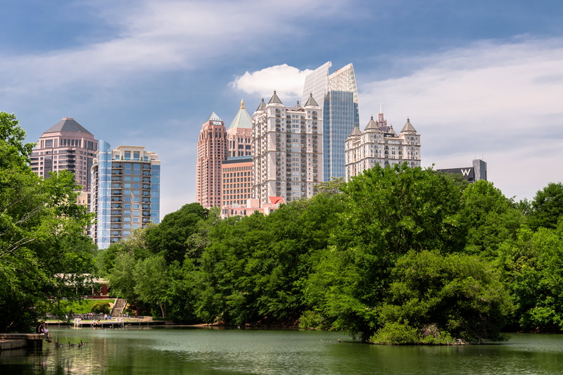 office building exterior, buildings, Piedmont, financial district, water, nature, cloud - sky, waterfront, building, cityscape, river, trees, day, building exterior