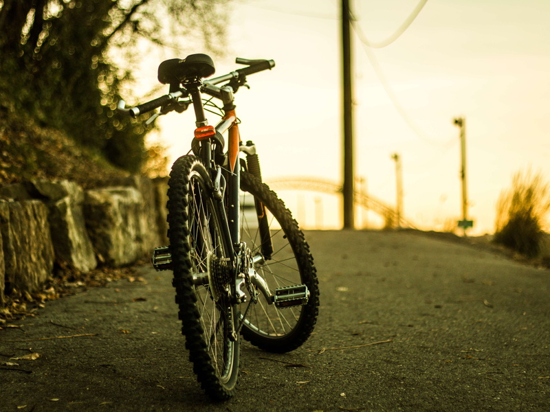 focus on foreground, city, orange skies, nature, close-up, night, land vehicle, photo, stationary, orange, metal, outdoors, afternoon, street, bicycle