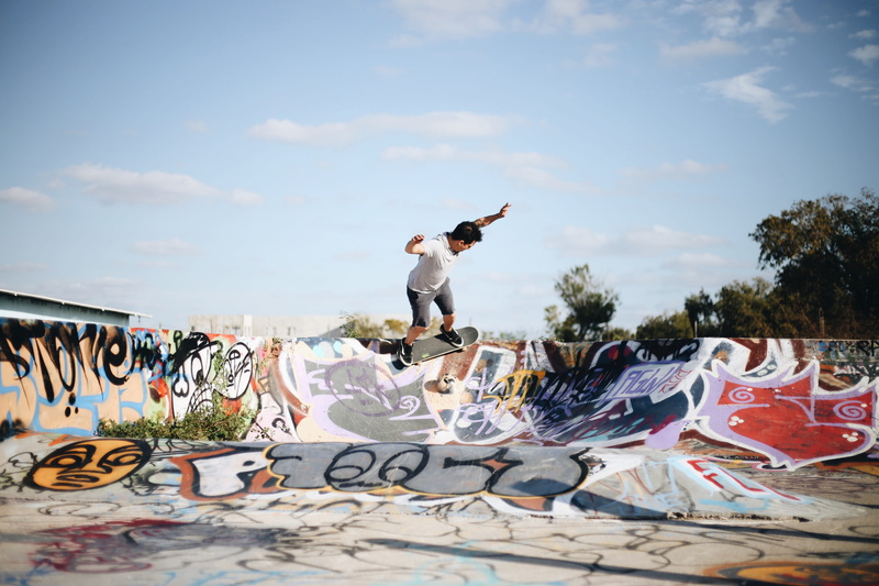 graffiti, riding, skateboard, daytime, full length, jumping, man, leisure activity, human arm, cloud - sky, text, sky, skateboarder, 5K, arms raised, stunt