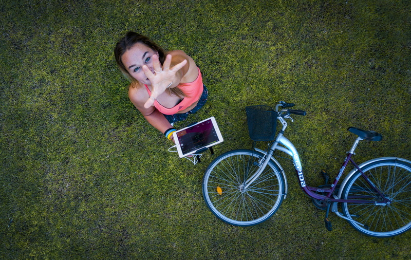 females, electronic, drone footage, girl, field, wheels, green color, hand, land, outdoors, one person, plant, relaxation, full length, day, high angle view