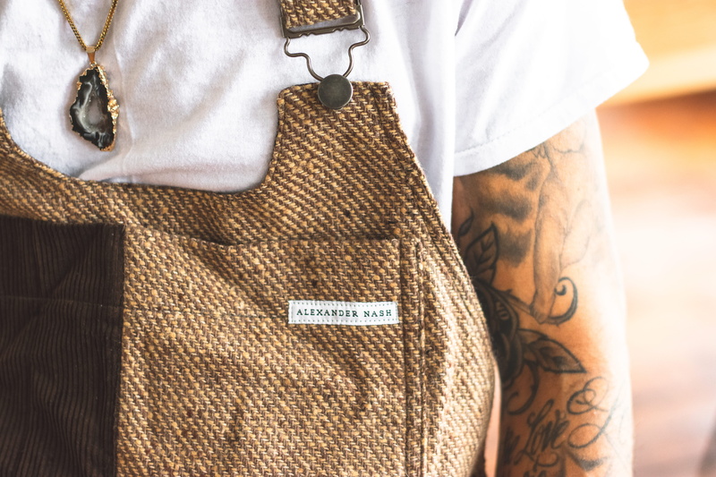 dungaree, clothing, real people, one person, human hand, handmade, warm clothing, lifestyles, text, person, button down shirt, human limb, 5K, brown, casual clothing