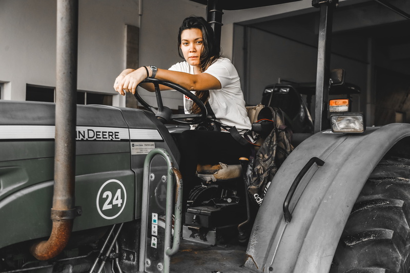 looking at camera, cushion, leisure activity, car wheel, occupation, mode of transportation, clothing, woman, apparel, machine, spoke, communication, chair