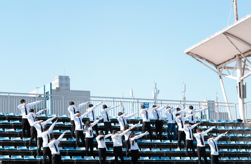 white color, in a row, bleachers, clothing, sunny, building, tower, handrail, banister, skyscraper, vehicle, wheel, group photo, clear sky, architecture