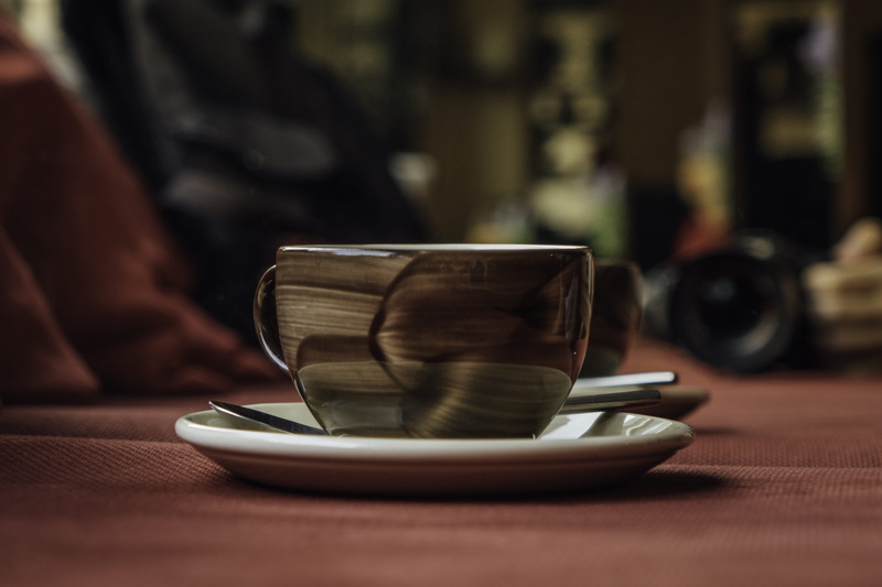 beverage, close-up, person, tea cup, green tea, espresso, selective focus, furniture, coffee shop, cafe, human, surface level, sideboard, focus on foreground