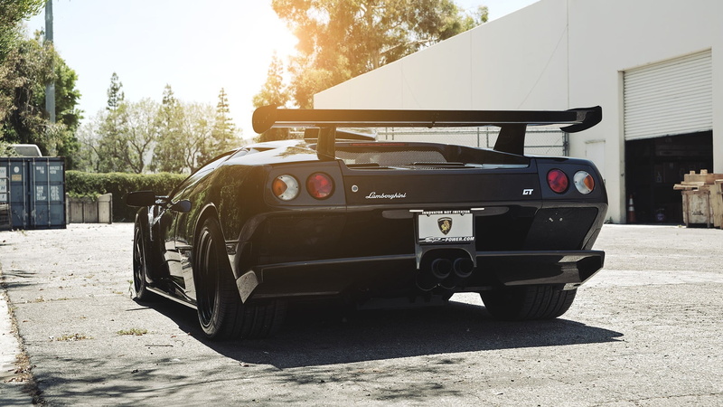 land vehicle, no people, sky, building exterior, black, outdoors, transportation, trailer, Lamborghini Diablo, road, utility, motor vehicle, nature, mode of transportation