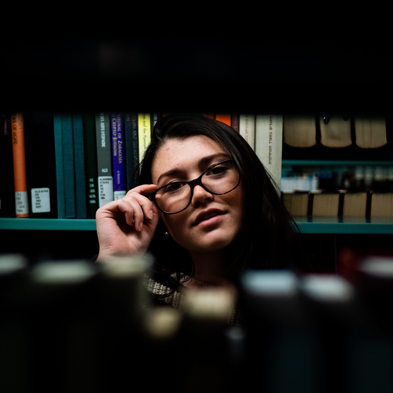 lifestyles, hairstyle, person, money, technology, young adult, communication, business, electronics, real people, bookcase, one person, adult, portrait