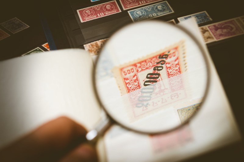 finance, magnifying glass, magnification, stamp collection, one person, human hand, business, zoom, studio shot, currency, indoors, paper currency, postage stamp