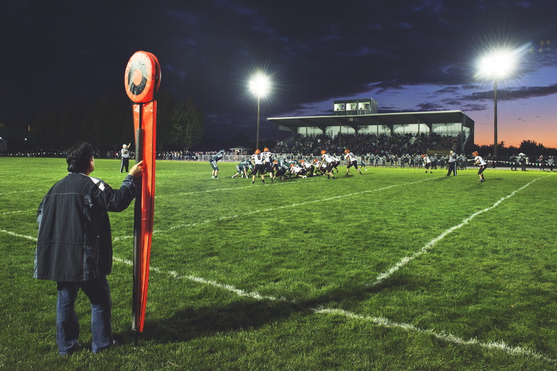 green color, holding, crowd, friday night light, green, clothing, side, sky, cloud, real people, light, lifestyles, football, playing field, nature, field