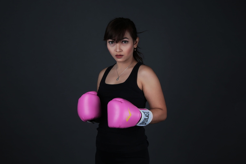 punching, pink color, standing, black background, copy space, beautiful woman, waist up, boxing gloves, boxing, strength, portrait, sport, lifestyles, brand