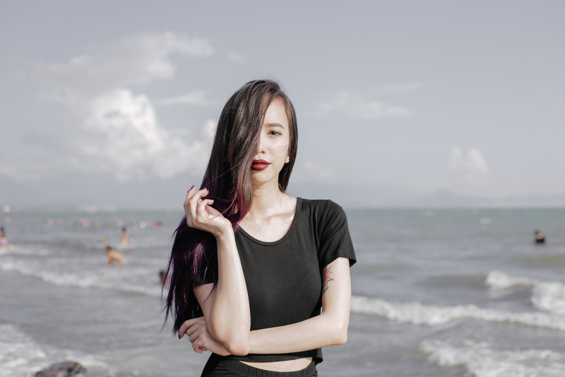 front view, land, day, beach, hair, long hair, one person, focus on foreground, beautiful woman, casual clothing, women outdoors purple hair black lipstick model beach black black outfits lace fashion makeup photography
