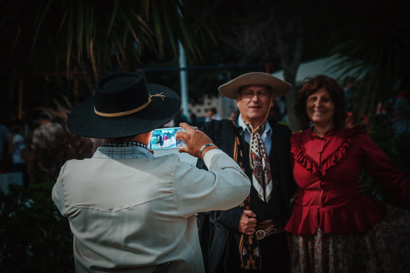 women, focus on foreground, holding, smiling, cell, clothing, three quarter length, hats, la plata, men, standing, couple, people, phone, leisure activity