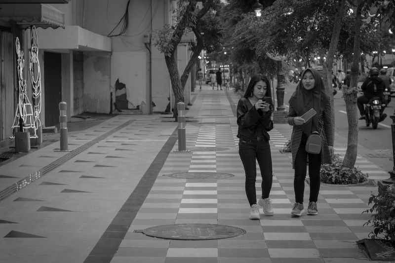 teenager, full length, walking, incidental people, built structure, architecture, two people, city, footpath, black white, indonesia, casual clothing, black