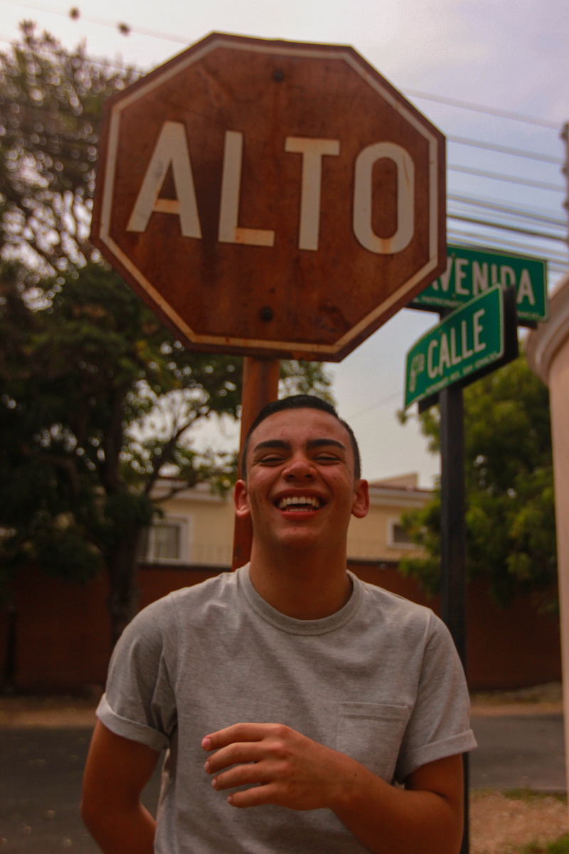 signs, emotion, symbol, road, outdoors, stop, portrait, looking at camera, western script, casual clothing, men, sign, honduras, day, person, clothing