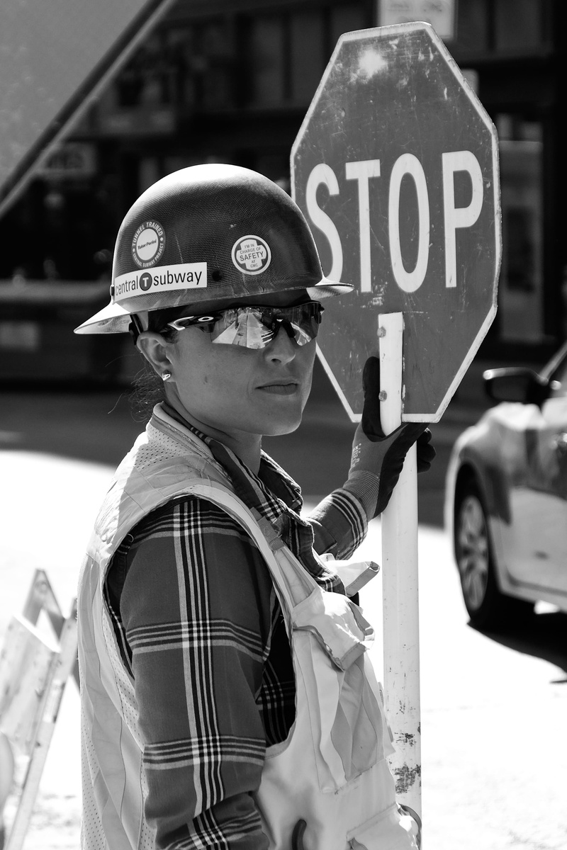 real people, stop, motor vehicle, men, road sign, vehicle, wheel, machine, communication, day, near, human, holding, side view, apparel, security, car