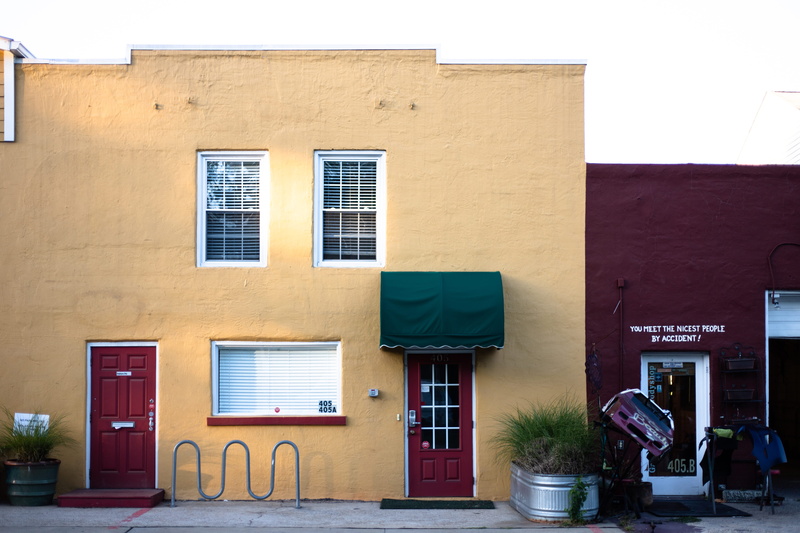 town, wall - building feature, sky, potted plant, awning, outdoors, plant, road, window shade, built structure, closed, communication, residential district