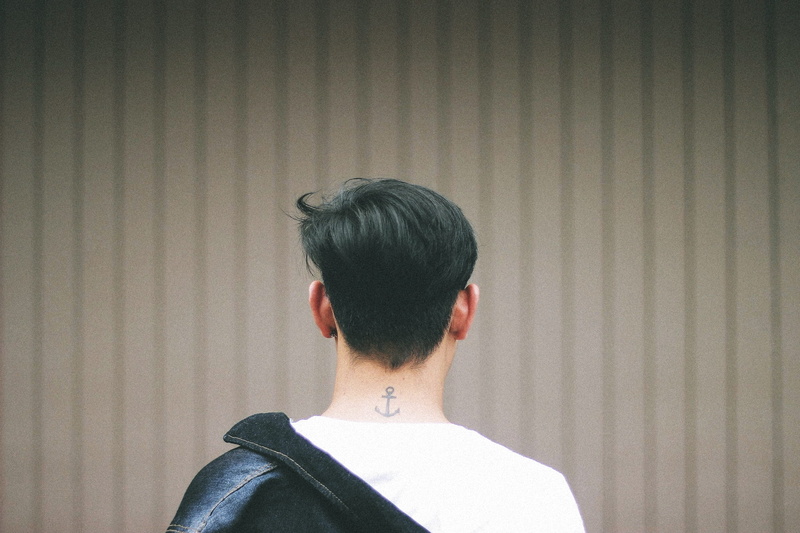 men, wall - building feature, male, alone, portrait, lifestyles, jacket, neck, anchor, headshot, tattoo, white, young adult, built structure, man, hairstyle