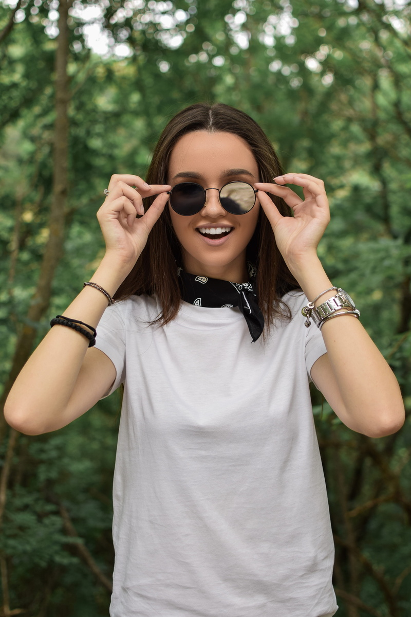 sunglasses, plant, glasses, outdoors, smiling, one person, tree, leisure activity, 5K, focus on foreground, looking at camera, standing, happiness, hairstyle