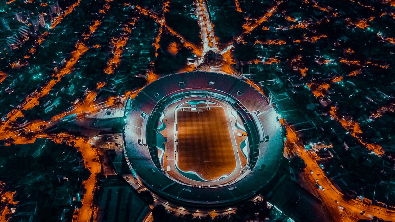outdoors, drone shot, building, sports field, geometric shape, orange color, field, architecture, city, shape, high angle shot, circle, eye, high angle view