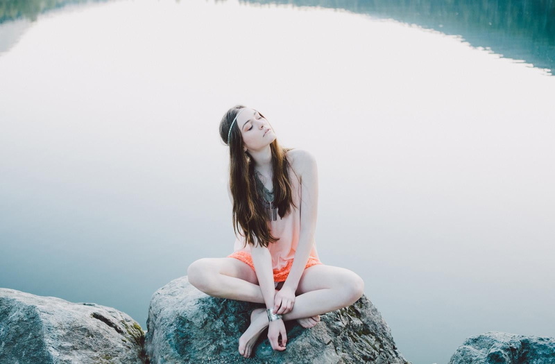 rock, nature, hair, rock - object, sitting, headband, three quarter length, day, brunette, beauty, lifestyles, long hair, hairstyle, beautiful woman, barefoot