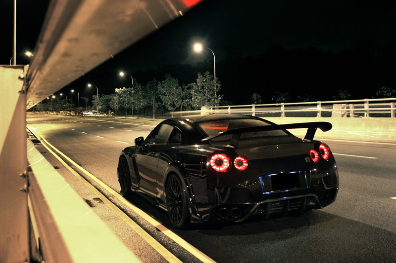 street light, travel, architecture, parking garage, parking lot, land vehicle, road, illuminated, coupe, on the move, motor vehicle, night, motion, spoiler