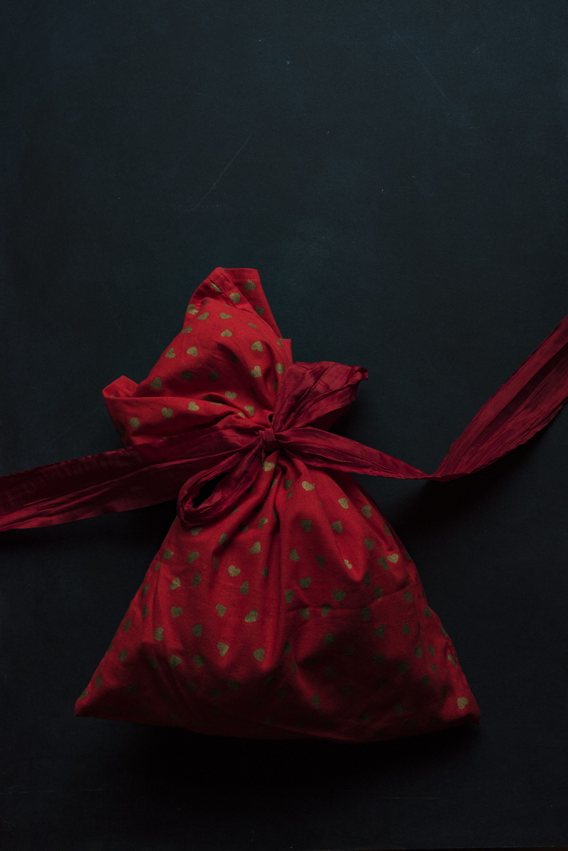 gift, studio shot, red, polka, food and drink, black, table, indoors, bag, surface, gold, single object, freshness, food, bow, black background, no people