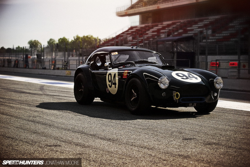 city, sunlight, tire, car, mode of transportation, road, transportation, architecture, outdoors, street, motor racing track, no people, black cars, wheel