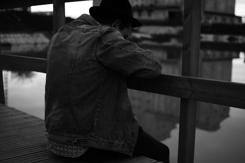 black, focus on foreground, black and white, men, water, lifestyles, bench, hood - clothing, day, one person, sitting, 1080P, railing, unrecognizable person