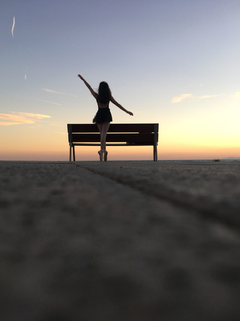 hardwood, real people, sunlight, leisure activity, woman, table, one person, sitting, park bench, furniture, beach, water, person, outdoors, 2K, photography