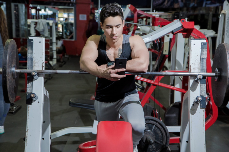 smart phone, man, bodybuilder, exercise equipment, weight, mobile phone, sitting, indoors, fitness, wear, body, strength, looking, resting, portable information device