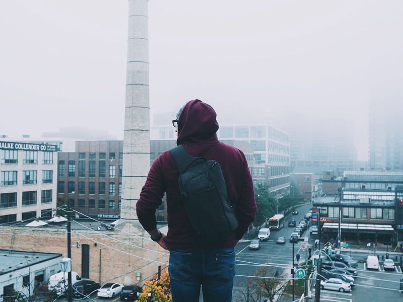 black, warm clothing, backpack, covered, wearing, skyscraper, top, daytime, city life, day, one person, three quarter length, winter, guy, architecture