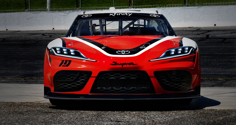 communication, car, sport, mode of transportation, competitive sport, 2019, transportation, red, city, text, number, outdoors, racecar, garage, land vehicle