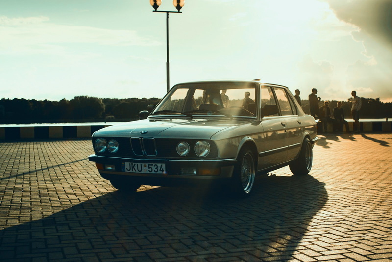 720P, motor vehicle, sports car, outdoors, street, city, travel, nature, BMW, evening, e28, sports, shadow, people, sunlight, incidental people, Sun, paving stone